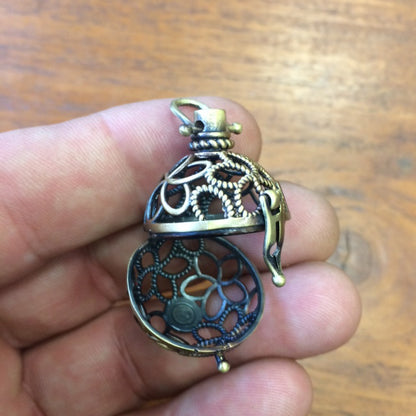 Pendentif/ Cage à pierre, peut servir de Bolas (pendentif de grossesse) ou pour perle de lave pour huile essentielle ! 2,5 centimètres de diamètre. Fait en laiton ! Vendu avec une perle de lave de 10mm !