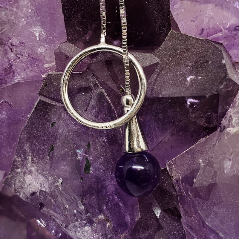 Delicate 0.925 silver chain, adorned with a ring-shaped pendant, specially designed to hold an 8 mm amethyst bead. This bead can be inserted into the ring, allowing it to be worn around the neck with elegance.