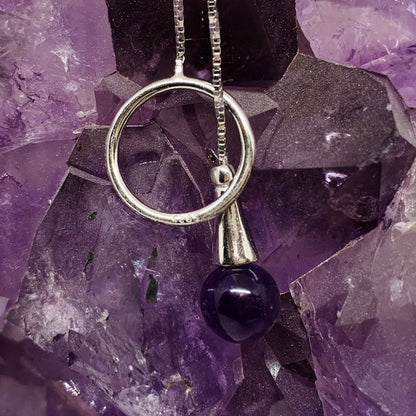 Delicate 0.925 silver chain, adorned with a ring-shaped pendant, specially designed to hold an 8 mm amethyst bead. This bead can be inserted into the ring, allowing it to be worn around the neck with elegance.