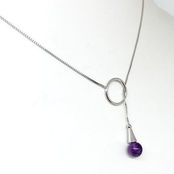Delicate 0.925 silver chain, adorned with a ring-shaped pendant, specially designed to hold an 8 mm amethyst bead. This bead can be inserted into the ring, allowing it to be worn around the neck with elegance.