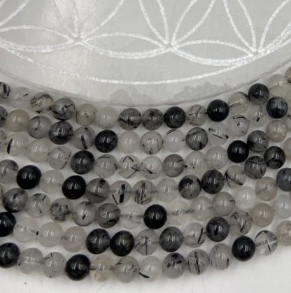 Tourmaline Noire avec Quartz de qualité, perles rondes de 6 et 8 mm, vendu en : fil de perle 38/39 cm, en bracelet de 17 à 21cm, en collier de 45 ou sautoir de 60cm. Qualité AA à AAA, superbes perles naturellement cristalline !