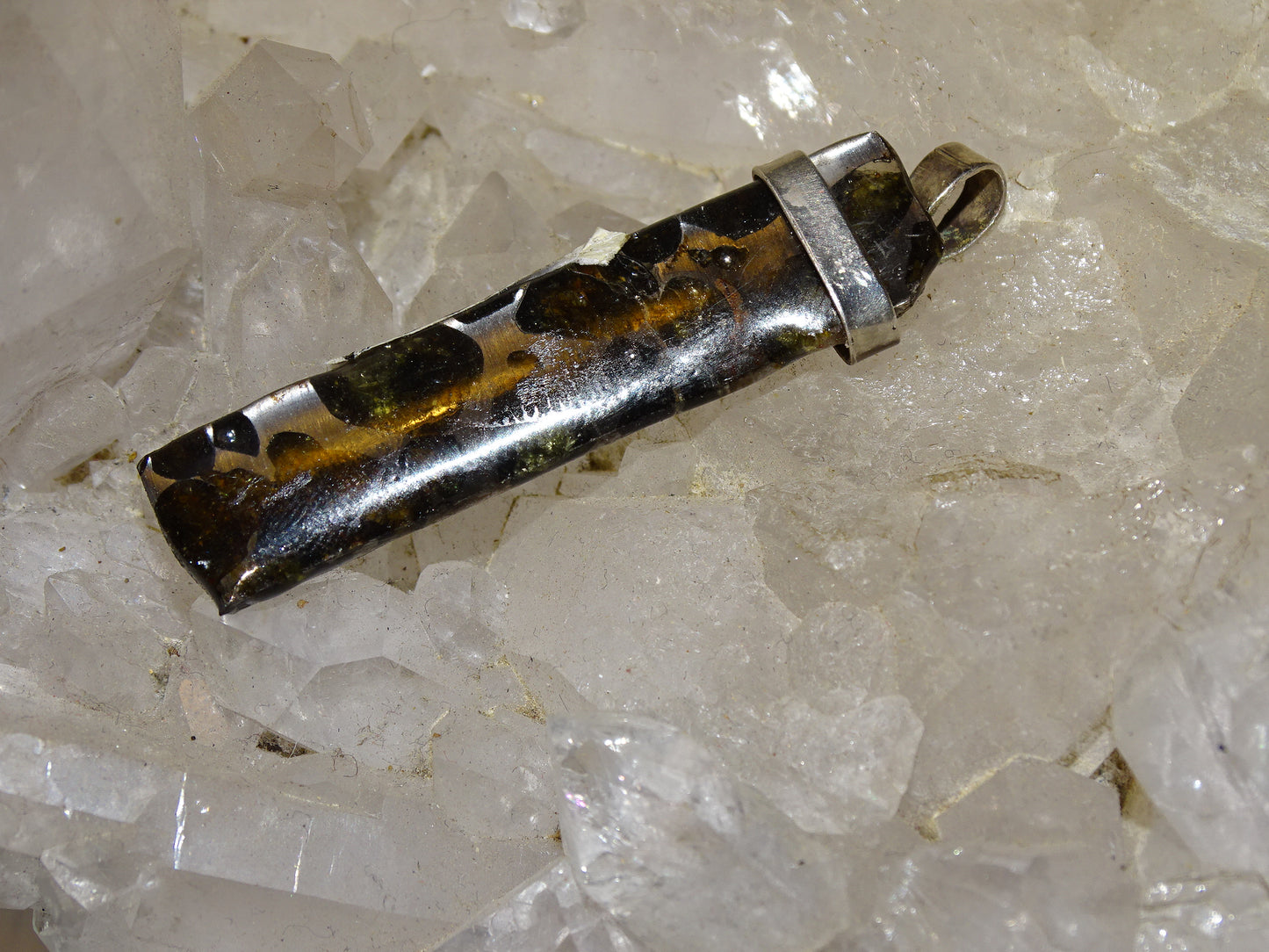 Météorites Pallasites Sericho, pendentif en Argent de 5 gr., 50 x 12 x 5 mm. Piéce rare et se distingue par la présence de gros cristaux d'olivine (péridot) en inclusion !