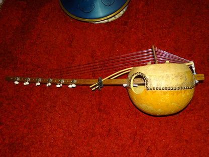 Kamélé n'Goni de 12 cordes (nylon), fait au Mali dans la tradition ! 1,10 mètres de hauteur, caisse en potiron de 35 centimètres de diamètre. Le son est proche d'un kalimba, une douceur incroyable, la harpe Africaine !