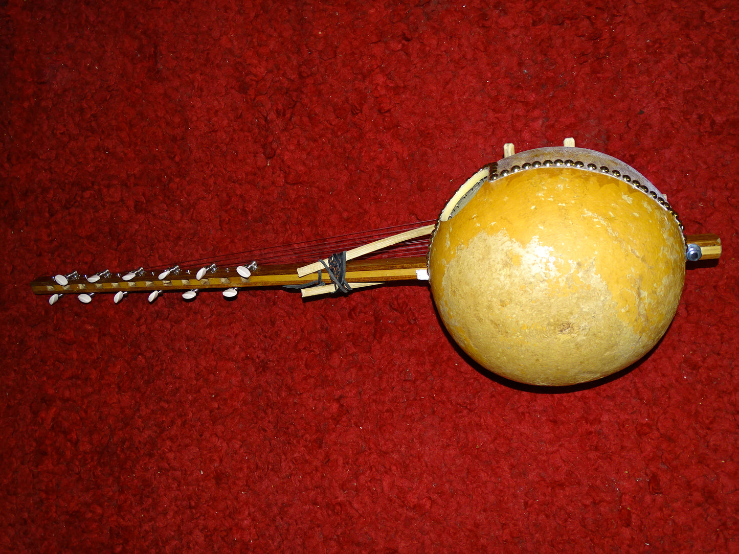 Kamélé n'Goni de 12 cordes (nylon), fait au Mali dans la tradition ! 1,10 mètres de hauteur, caisse en potiron de 35 centimètres de diamètre. Le son est proche d'un kalimba, une douceur incroyable, la harpe Africaine !