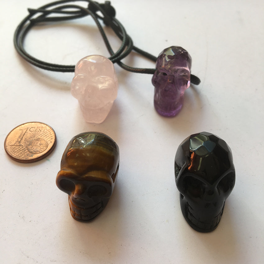Pendentif en forme de crâne, symbole de la connaissance ! De 18 millimètres de hauteur x 16 mm de largeur. Pierre au choix : Améthyste, Obsidienne, Quartz rose, Oeil de tigre. Vendu avec cordon noir réglable offert, parfait !
