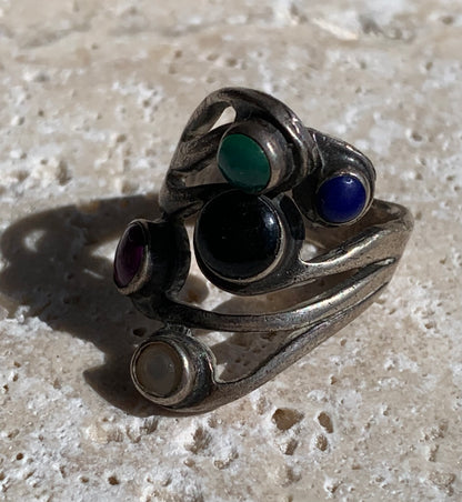 Élégante bague avec 5 pierres semi-précieuses, montée Argent 0.925. Superbes petits cabochons ronds à 5 couleurs. Très belle réalisation ! Taille de 54 Fr ! Bague de seconde main !