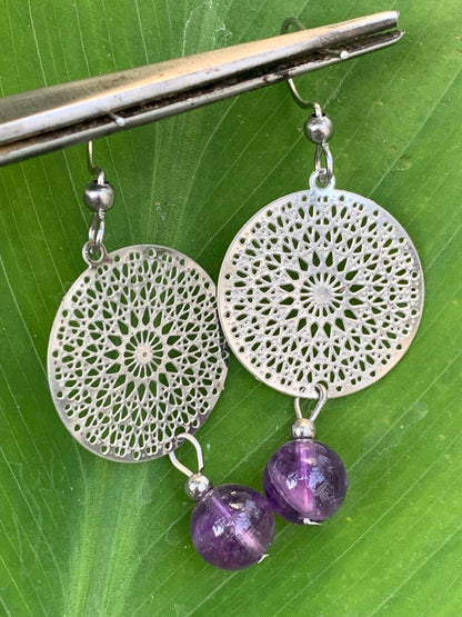 Boucles d'oreilles en Améthyste avec un superbe Mandala en Argent où est suspendue une perle ronde, qualité AA à AAA. Vendu en finition Argent 0.925, parfait !