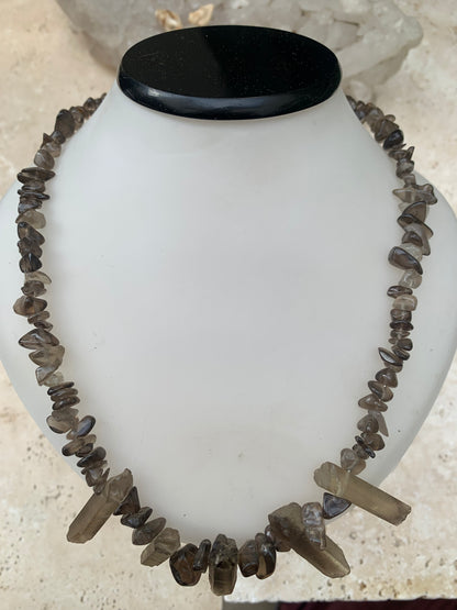 Cristal de roche fumé/ Quartz fumé, en collier de 42 centimètres. Perle de type 'baroque/ chips' de 4 à 7 millimètres avec 5 cristaux naturels en panoramique, fermoir de type 'mousqueton' !