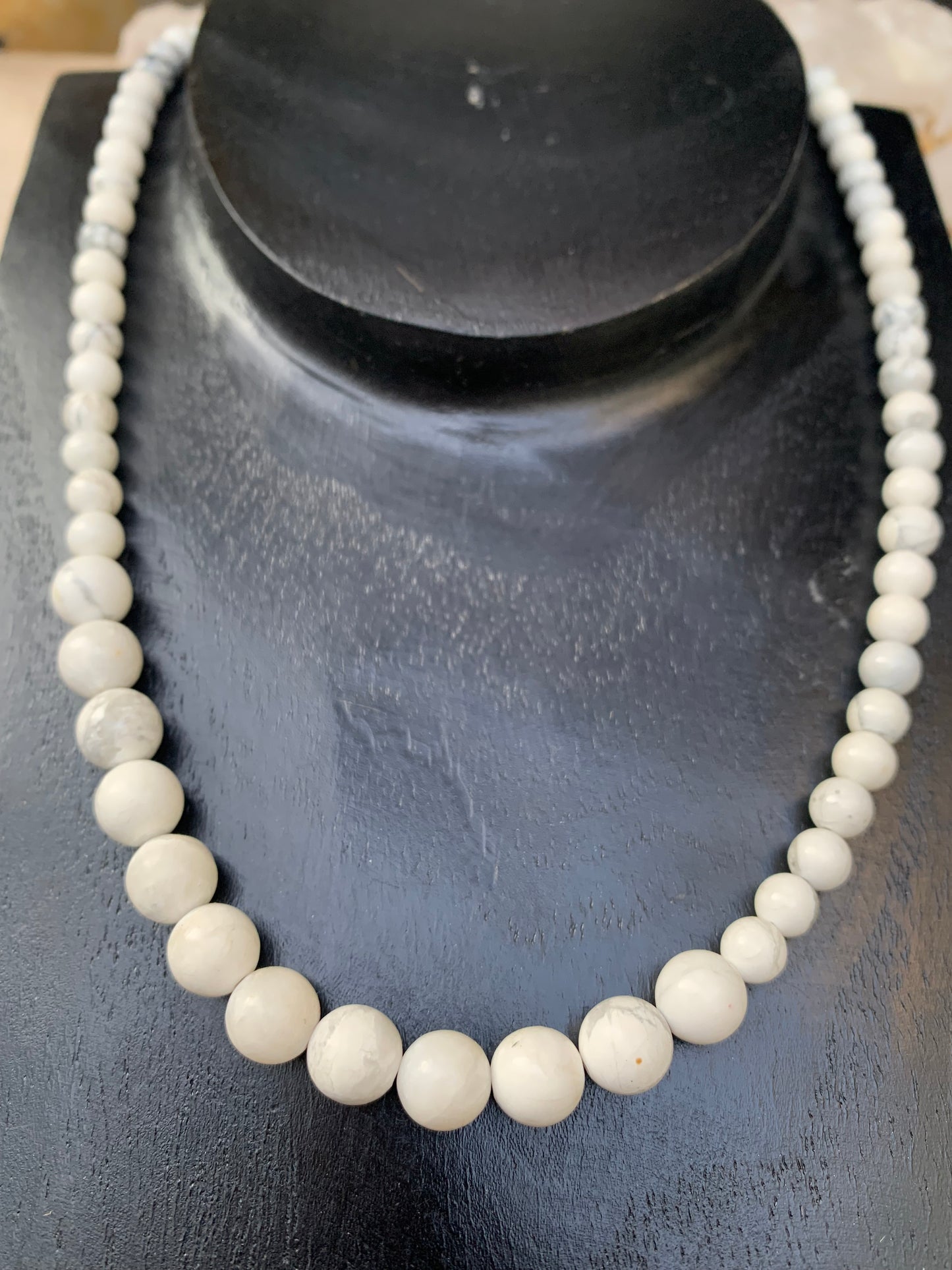 Howlite, 'collier/ chute de perle', de forme ronde de 4 à 10 millimètres de diamètre. 44 centimètres de longueur + 4 cm de rajout en chaînette. Fermoir de type 'mousqueton'. Très belle pièce !