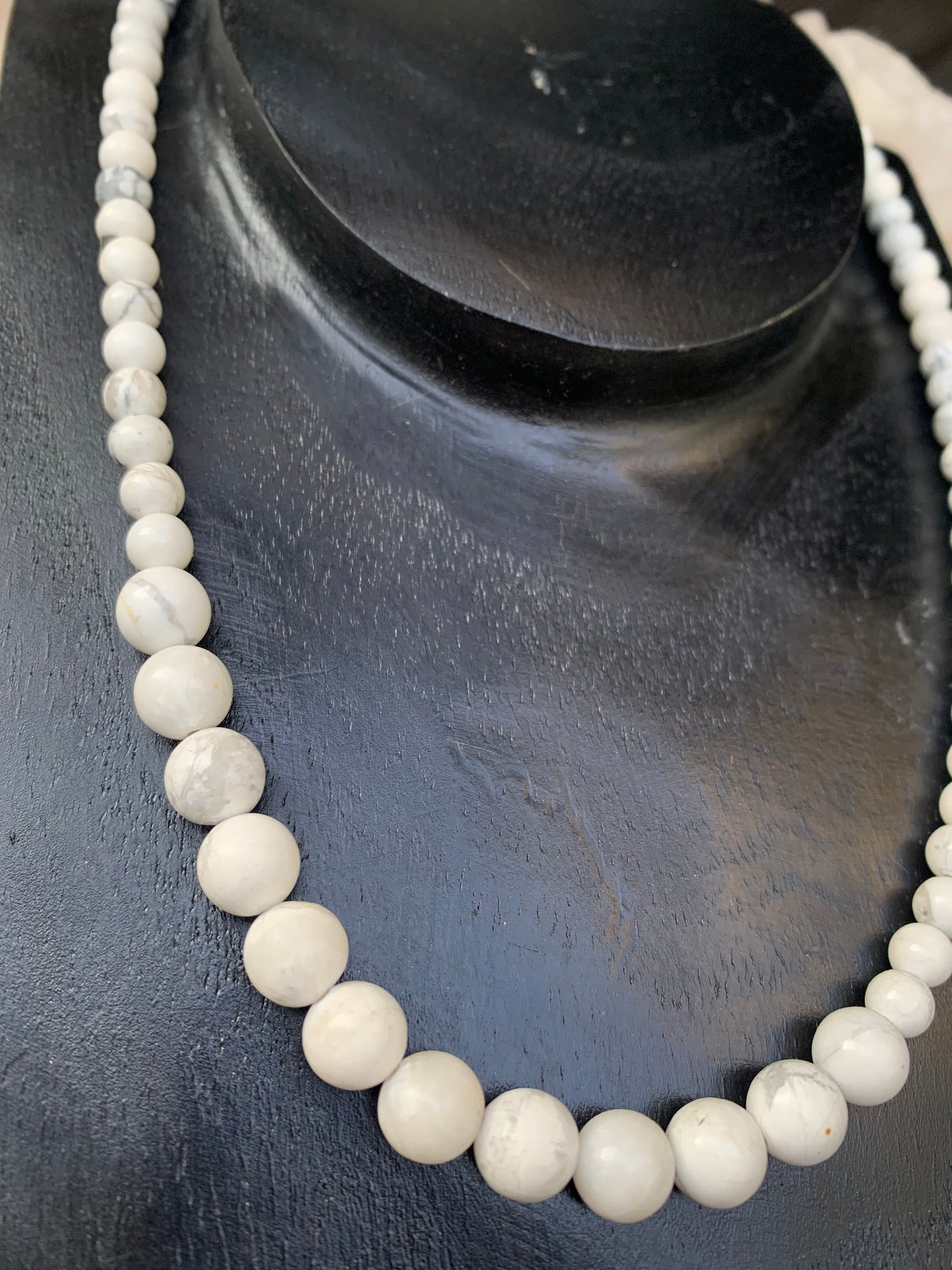Howlite, 'collier/ chute de perle', de forme ronde de 4 à 10 millimètres de diamètre. 44 centimètres de longueur + 4 cm de rajout en chaînette. Fermoir de type 'mousqueton'. Très belle pièce !
