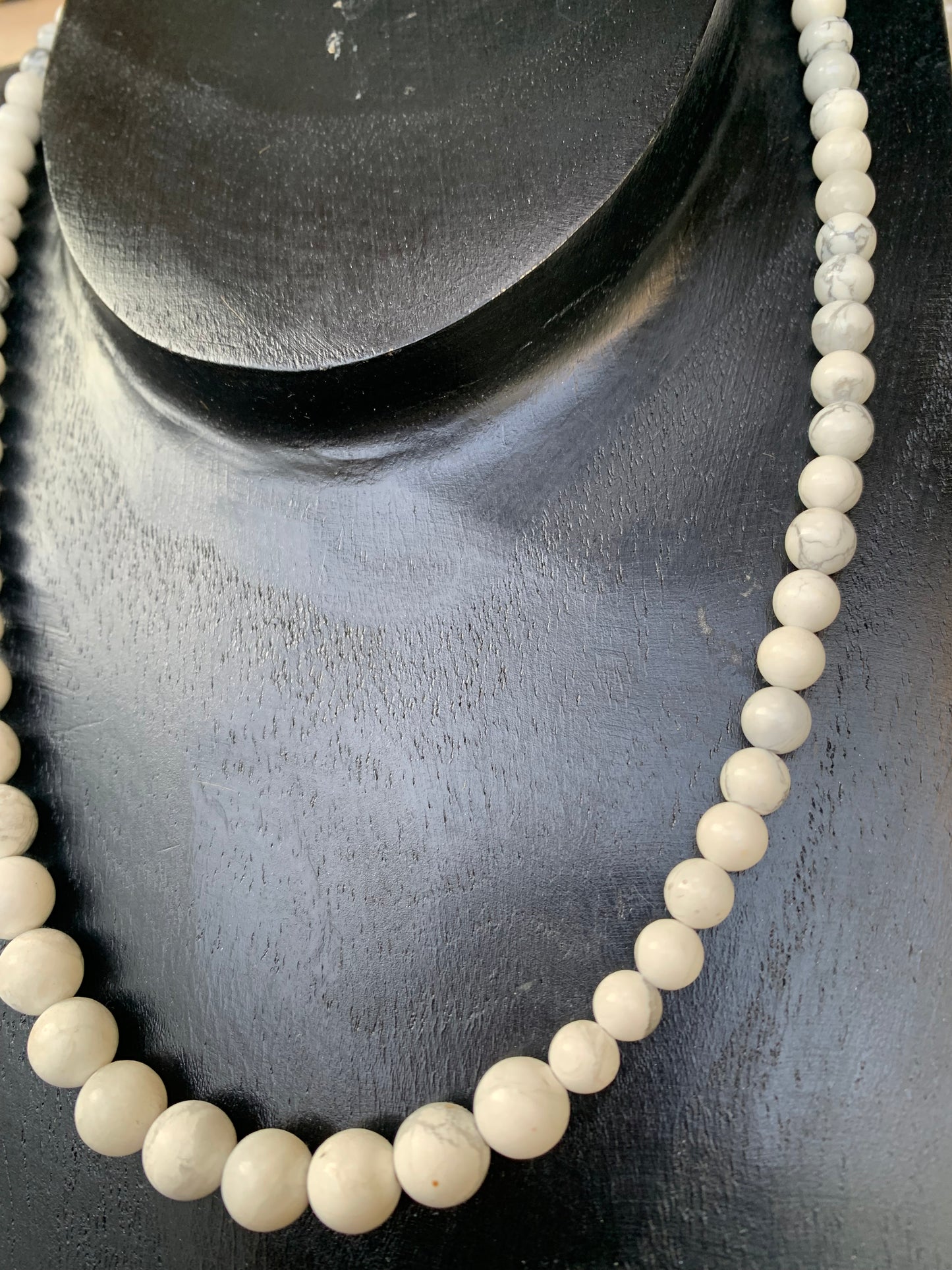 Howlite, 'collier/ chute de perle', de forme ronde de 4 à 10 millimètres de diamètre. 44 centimètres de longueur + 4 cm de rajout en chaînette. Fermoir de type 'mousqueton'. Très belle pièce !