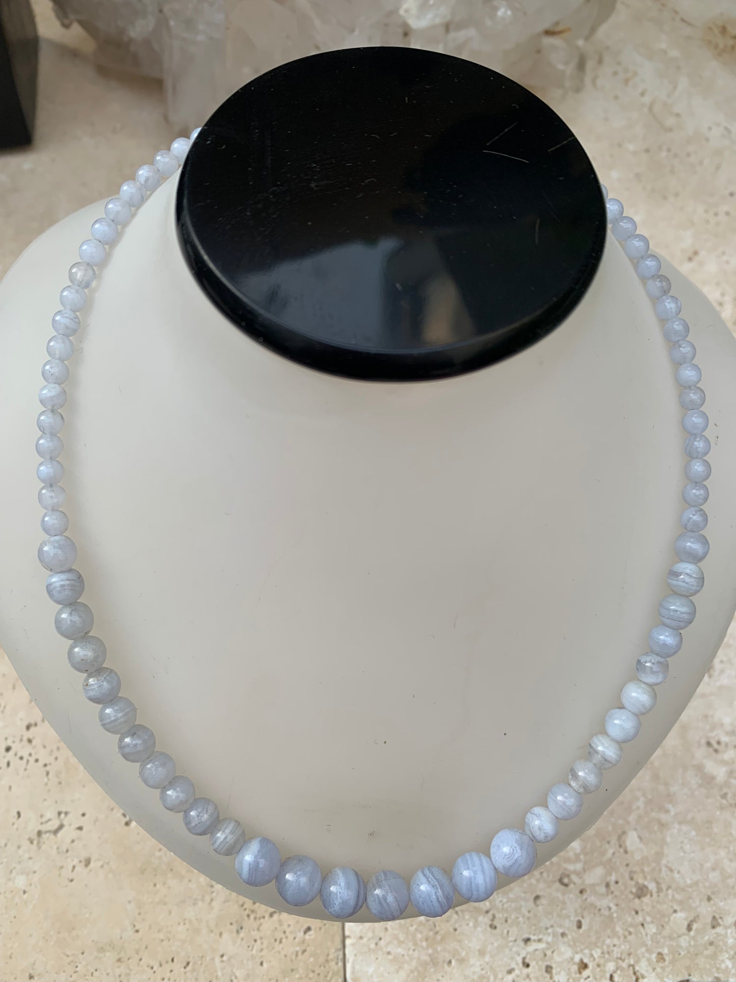 Agate Blue Lace, 'collier/ chute de perle', de forme ronde de 4 à 10 millimètres de diamètre. 44 centimètres de longueur + 4 cm de rajout en chaînette. Fermoir de type 'mousqueton'. Très belle pièce !
