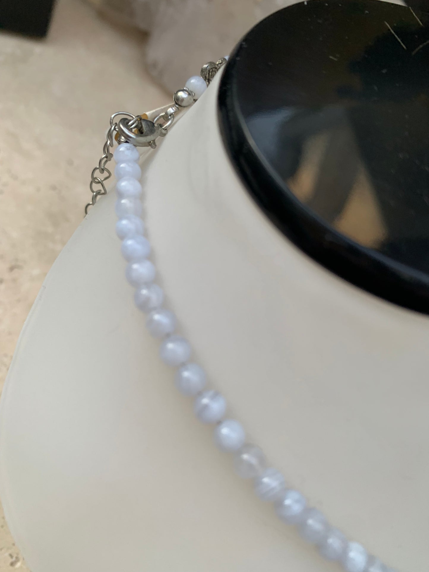 Agate Blue Lace, 'collier/ chute de perle', de forme ronde de 4 à 10 millimètres de diamètre. 44 centimètres de longueur + 4 cm de rajout en chaînette. Fermoir de type 'mousqueton'. Très belle pièce !
