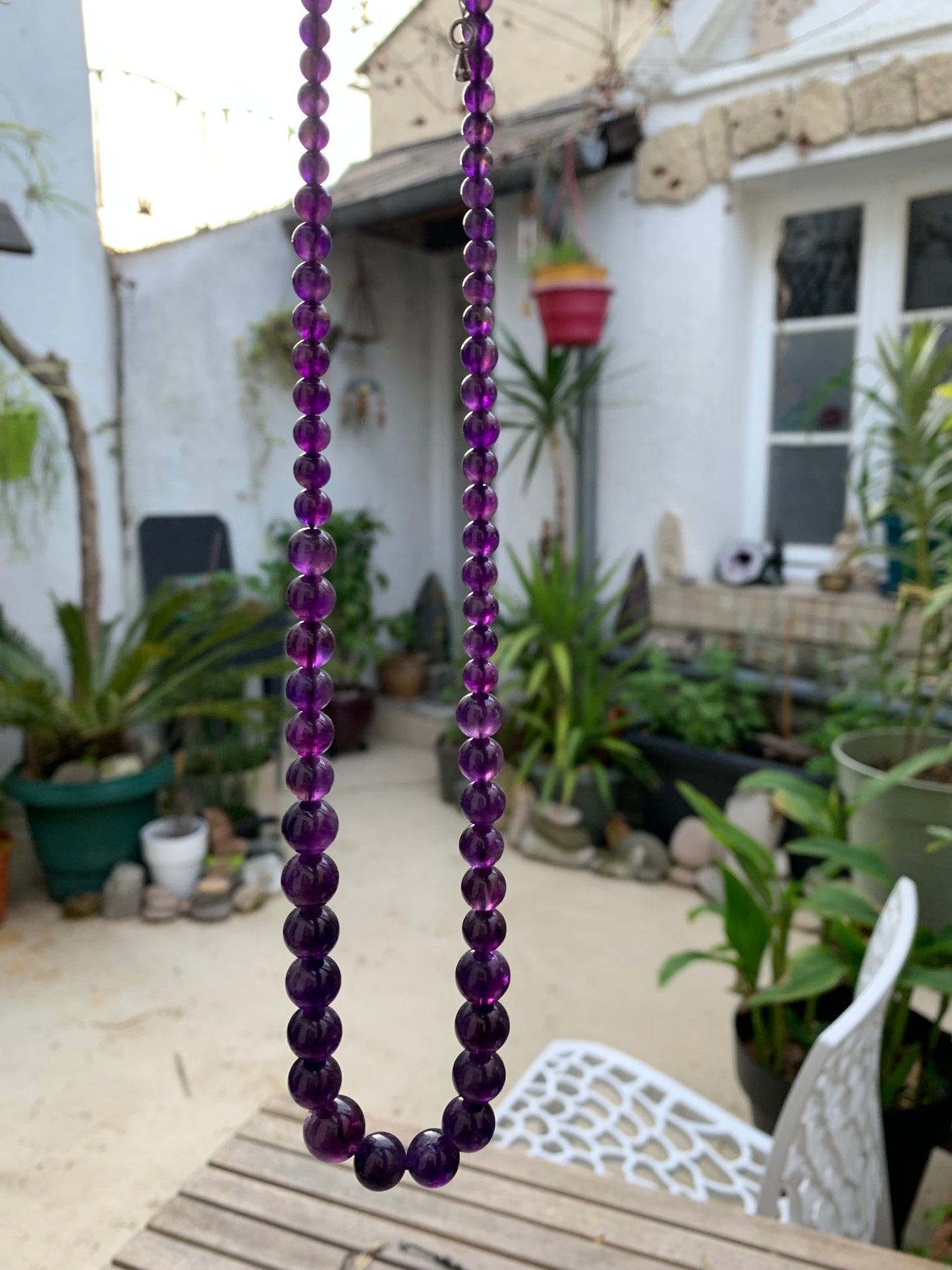 Améthyste, 'collier/ chute de perle', de forme ronde de 4 à 10 millimètres de diamètre. 50 centimètres de longueur + 4 cm de rajout en chaînette. Fermoir de type 'mousqueton'. Très belle pièce !