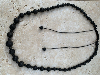 Pierre de lave, 'collier/ chute de perle', de forme ronde de 4 à 10 millimètres de diamètre. 50 centimètres de longueur. Fermeture coullissante de type 'Mala'. très belle pièce !