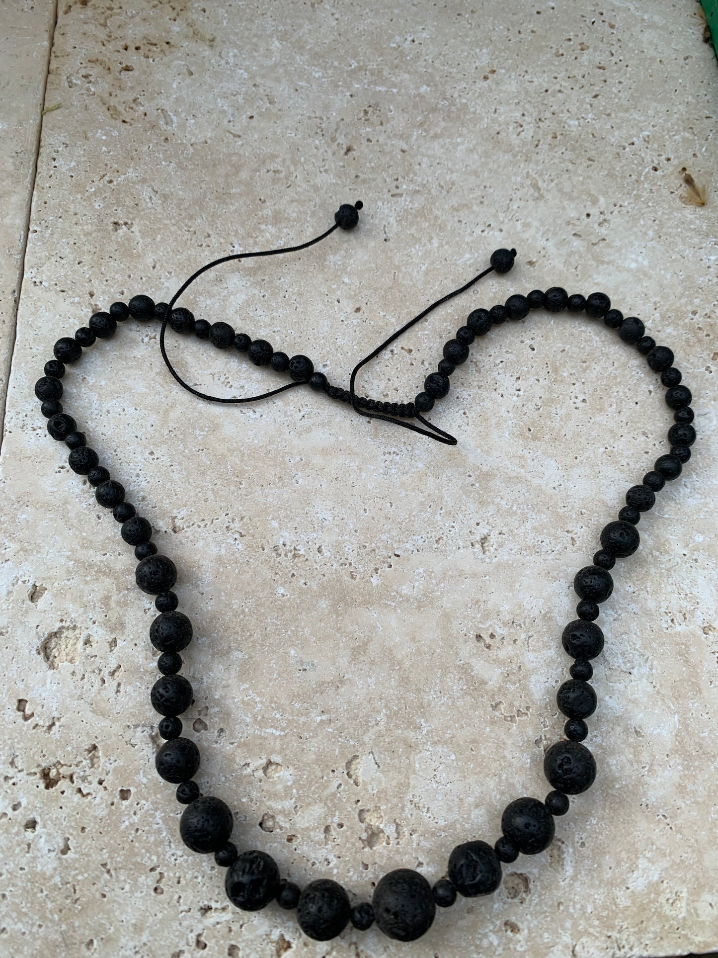 Pierre de lave, 'collier/ chute de perle', de forme ronde de 4 à 10 millimètres de diamètre. 50 centimètres de longueur. Fermeture coullissante de type 'Mala'. très belle pièce !