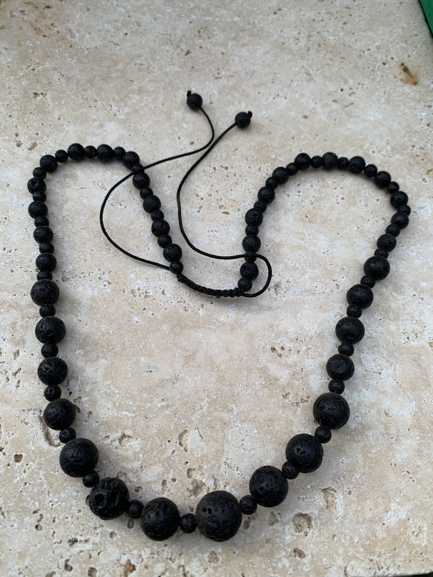 Pierre de lave, 'collier/ chute de perle', de forme ronde de 4 à 10 millimètres de diamètre. 50 centimètres de longueur. Fermeture coullissante de type 'Mala'. très belle pièce !
