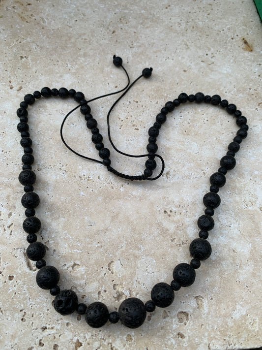 Pierre de lave, 'collier/ chute de perle', de forme ronde de 4 à 10 millimètres de diamètre. 50 centimètres de longueur. Fermeture coullissante de type 'Mala'. très belle pièce !