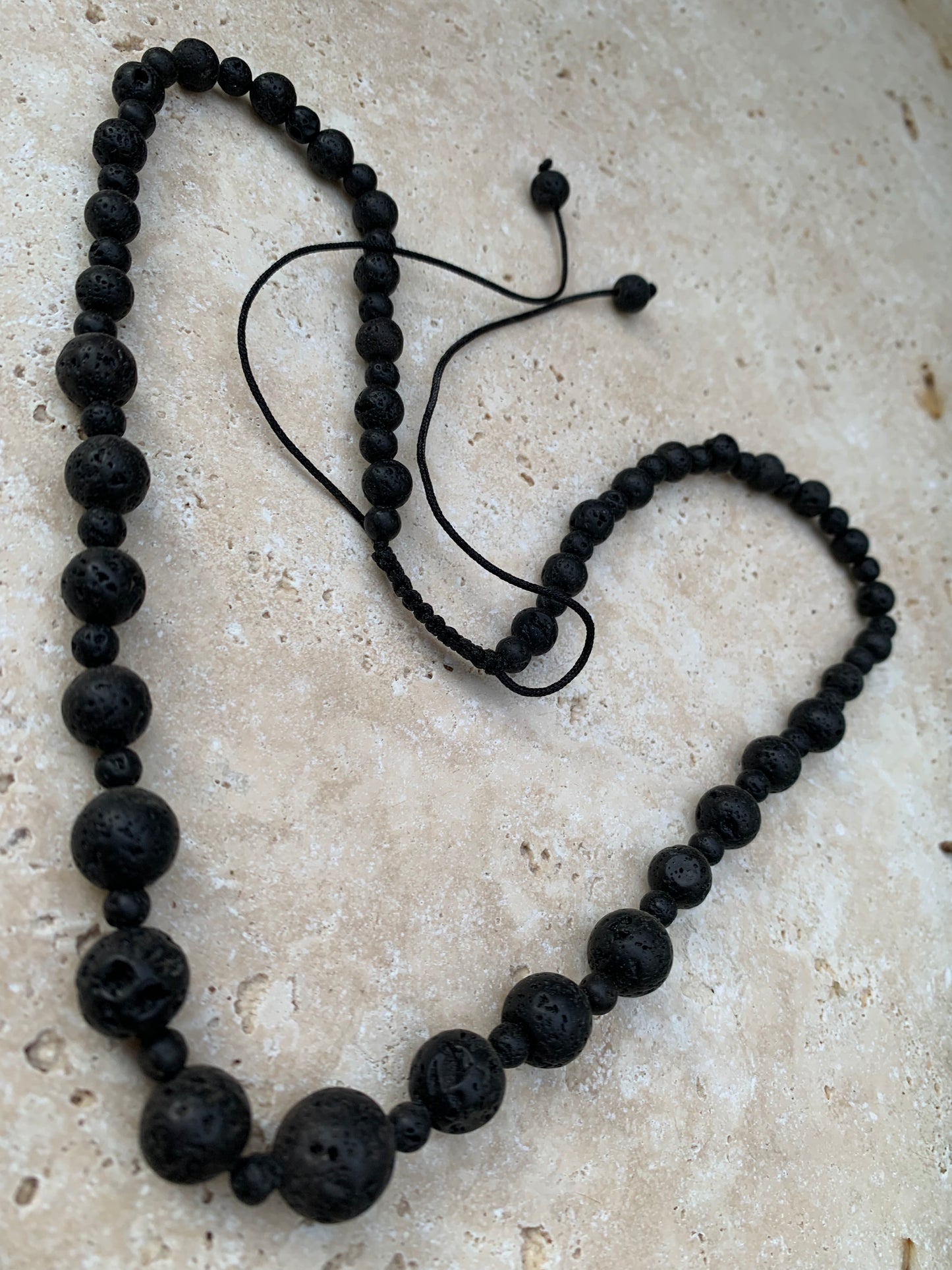 Pierre de lave, 'collier/ chute de perle', de forme ronde de 4 à 10 millimètres de diamètre. 50 centimètres de longueur. Fermeture coullissante de type 'Mala'. très belle pièce !