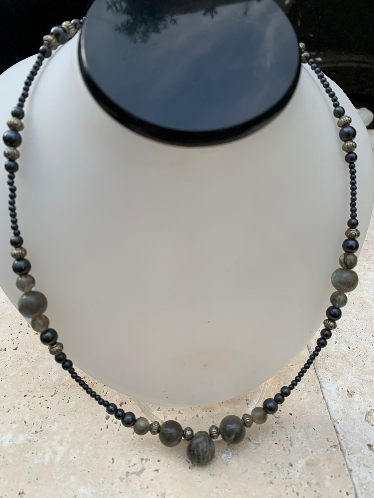 Labradorite avec hématite, 'collier/ chute de perle', de forme ronde de 2 à 10 millimètres de diamètre. 45 centimètres de longueur, fermoir à vis. Très belle pièce montée par Gem & Zen !