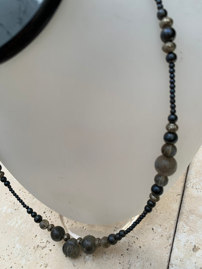 Labradorite avec hématite, 'collier/ chute de perle', de forme ronde de 2 à 10 millimètres de diamètre. 45 centimètres de longueur, fermoir à vis. Très belle pièce montée par Gem & Zen !