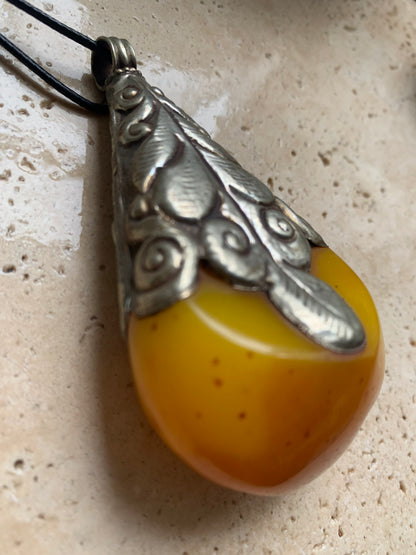 Pendentif en Copal (famille de l'Ambre), sertis en métal avec de majestueuses gravures. Impressionante pièce de 85 x 50 x 30 millimètres. Fait au Népal🇳🇵, un bijou ethnique unique et authentique (vendu avec cordon coulisant) !