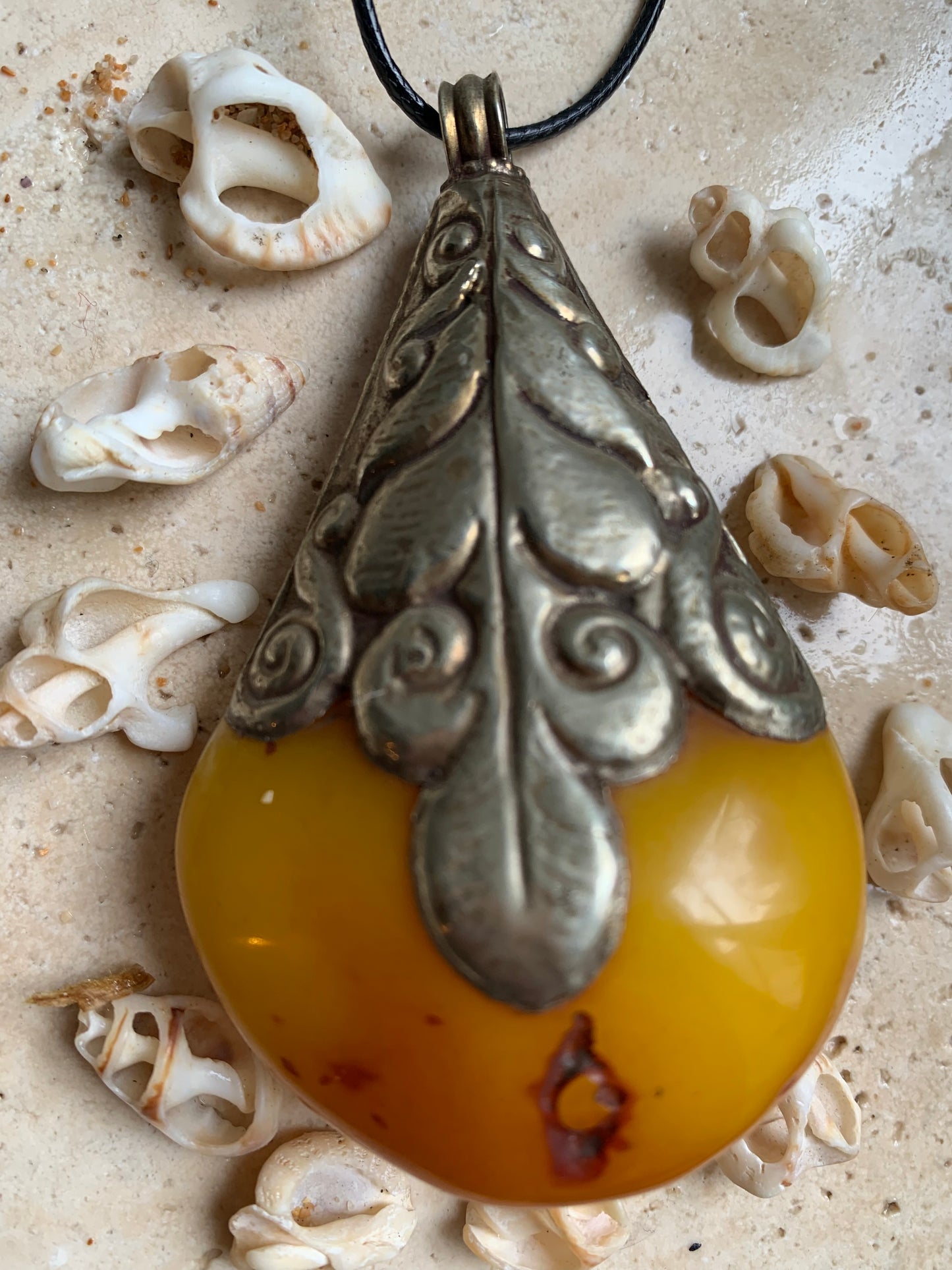 Pendentif en Copal (famille de l'Ambre), sertis en métal avec de majestueuses gravures. Impressionante pièce de 85 x 50 x 30 millimètres. Fait au Népal🇳🇵, un bijou ethnique unique et authentique (vendu avec cordon coulisant) !