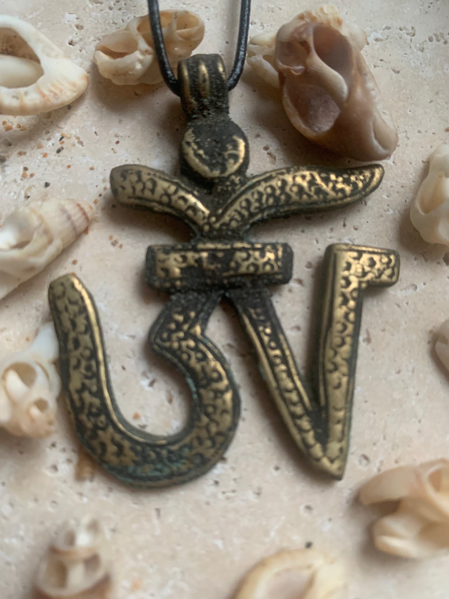 Om, symbole sacré en métal (laiton), taille de 60x50x10 millimètres. Pièce authentique et unique faîte au Népal. Livré avec cordon coulissant, prêt à porté ou à offrir !