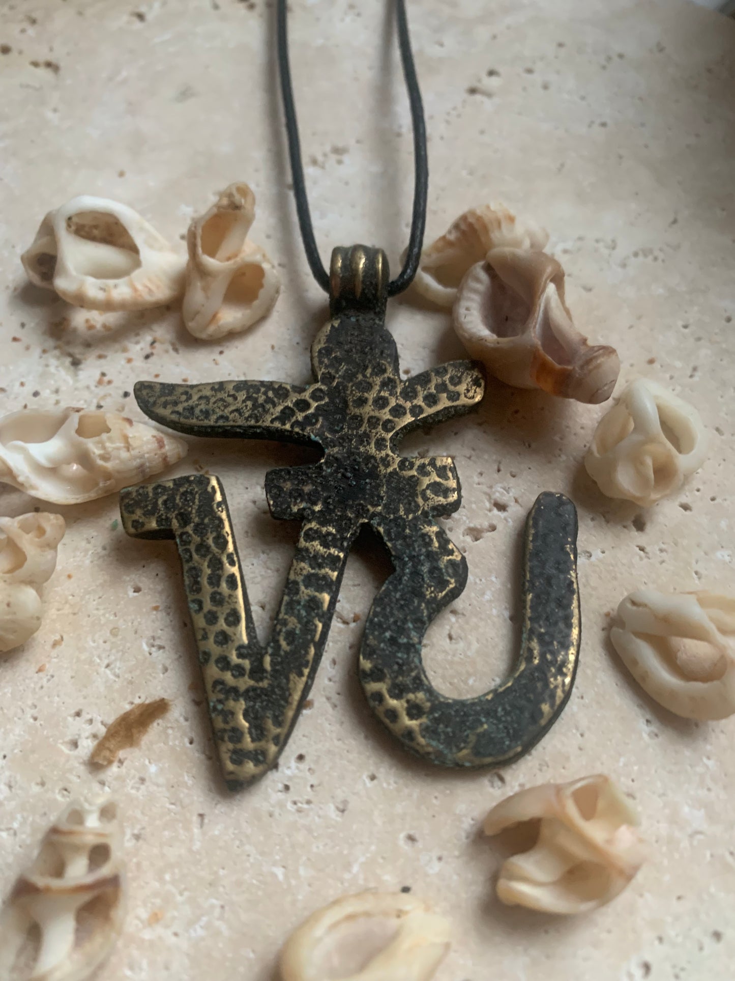 Om, symbole sacré en métal (laiton), taille de 60x50x10 millimètres. Pièce authentique et unique faîte au Népal. Livré avec cordon coulissant, prêt à porté ou à offrir !
