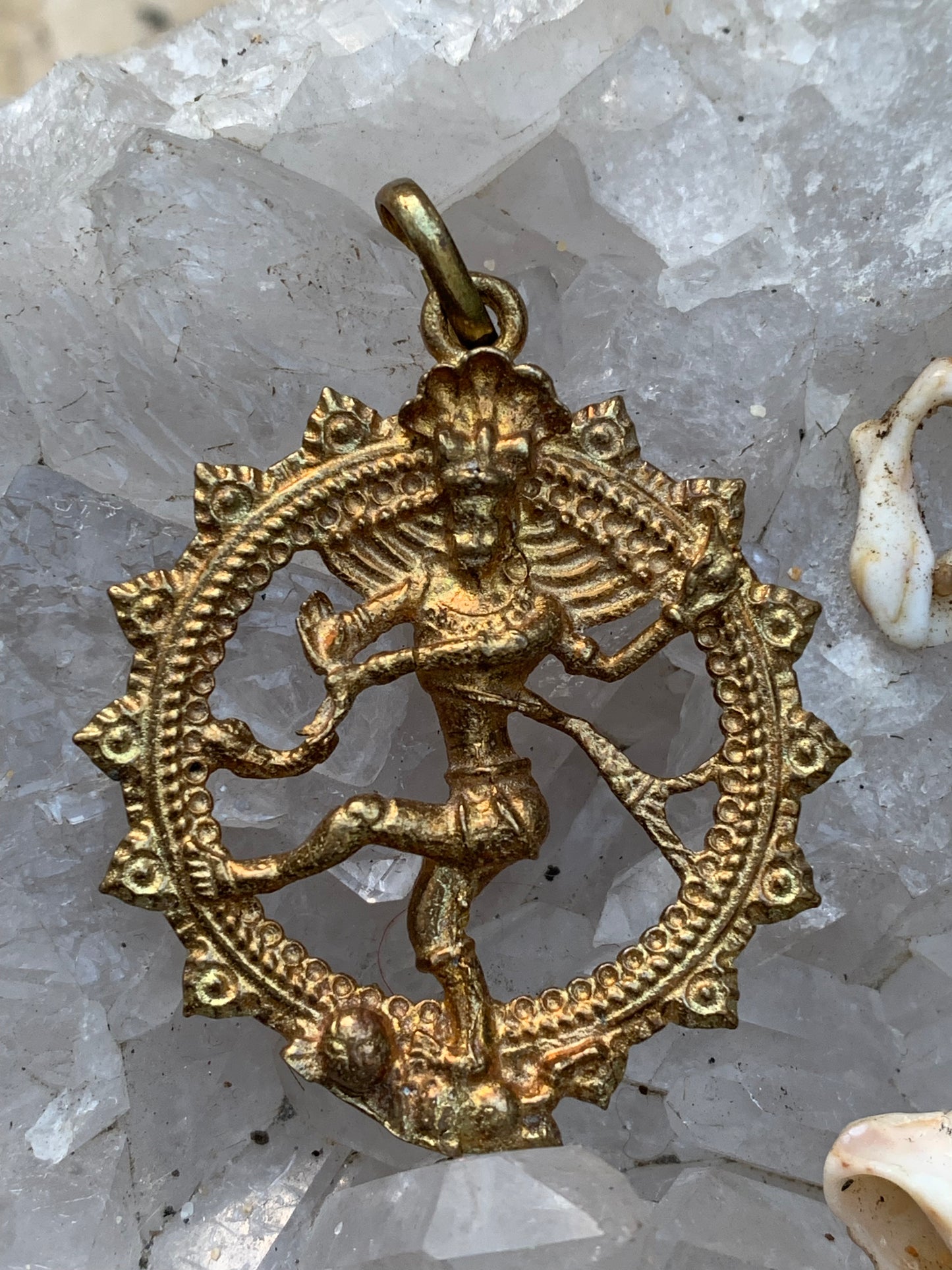 Pendentif en 'laiton argenté ou doré' de la divinité hindoue 'Shiva' sous sa forme de Shiva Nataraj. * Le roi (raja) de la danse (nata) est un symbole du mouvement éternel de l'univers, la danse cosmique. 4,5 cm de diamètre, vendu avec cordon !