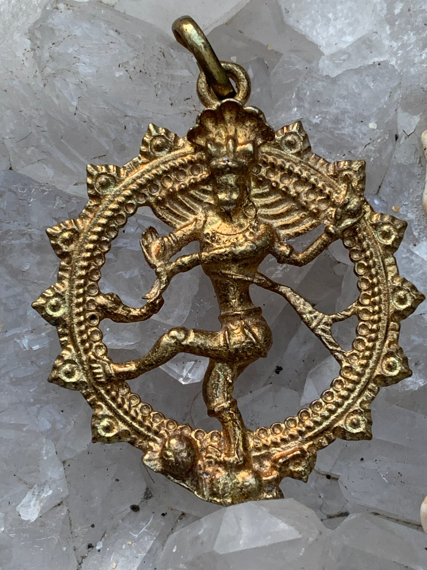 Pendentif en 'laiton argenté ou doré' de la divinité hindoue 'Shiva' sous sa forme de Shiva Nataraj. * Le roi (raja) de la danse (nata) est un symbole du mouvement éternel de l'univers, la danse cosmique. 4,5 cm de diamètre, vendu avec cordon !