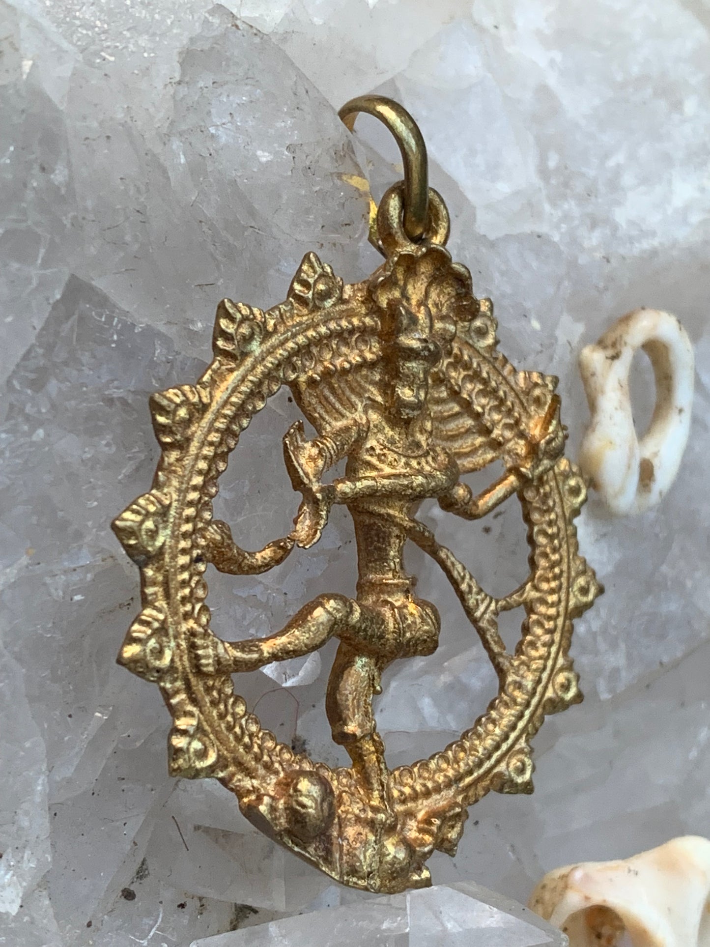 Pendentif en 'laiton argenté ou doré' de la divinité hindoue 'Shiva' sous sa forme de Shiva Nataraj. * Le roi (raja) de la danse (nata) est un symbole du mouvement éternel de l'univers, la danse cosmique. 4,5 cm de diamètre, vendu avec cordon !