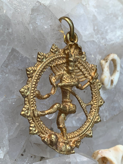 Pendentif en 'laiton argenté ou doré' de la divinité hindoue 'Shiva' sous sa forme de Shiva Nataraj. * Le roi (raja) de la danse (nata) est un symbole du mouvement éternel de l'univers, la danse cosmique. 4,5 cm de diamètre, vendu avec cordon !