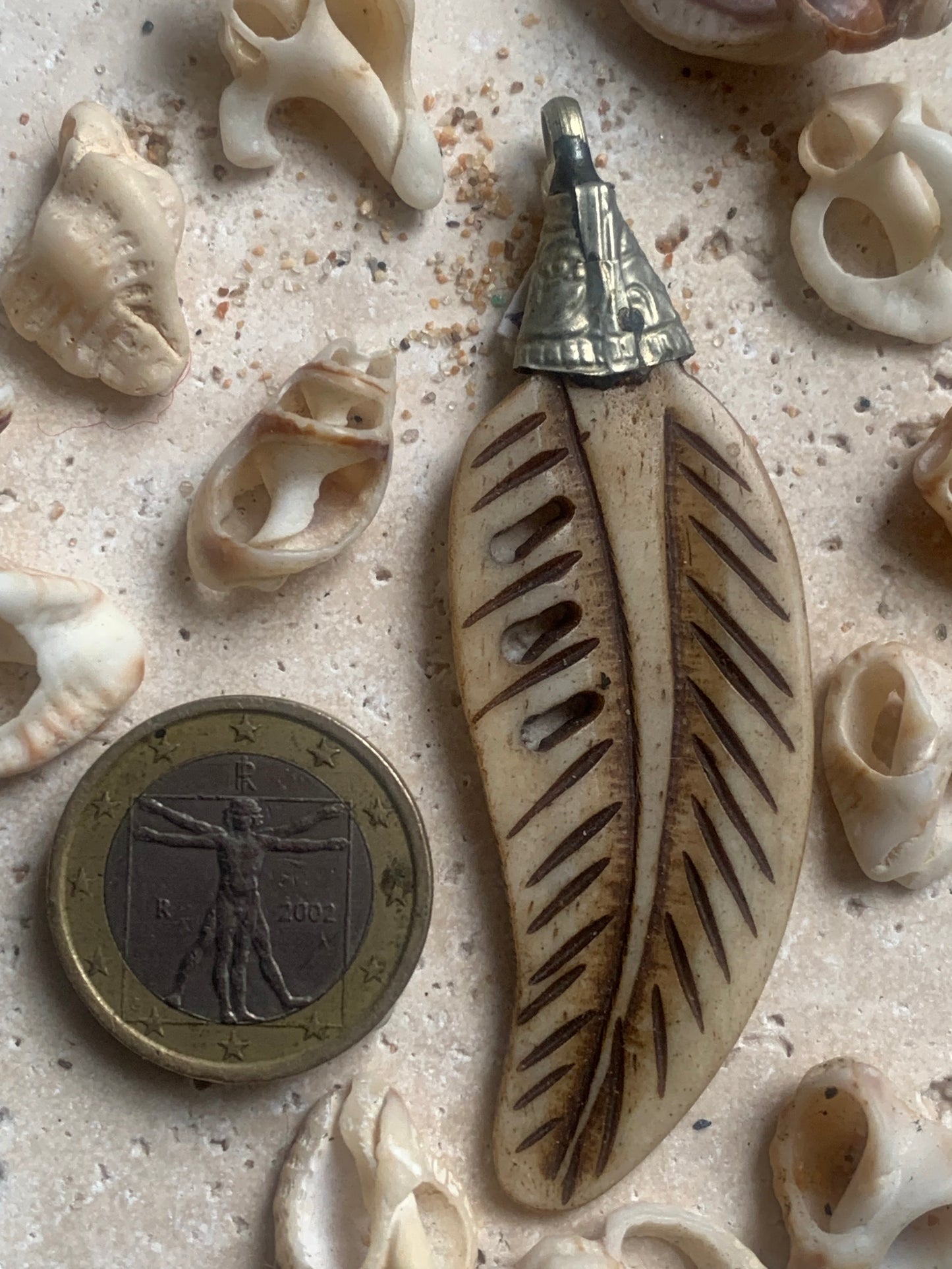 Pendentif artisanal du Népal en forme de plume, sculpté dans de l’os, de 70 millimètres de hauteur x 22 de largeur x 5 d'épaisseur. Vendu avec cordon noir réglable offert, parfait !