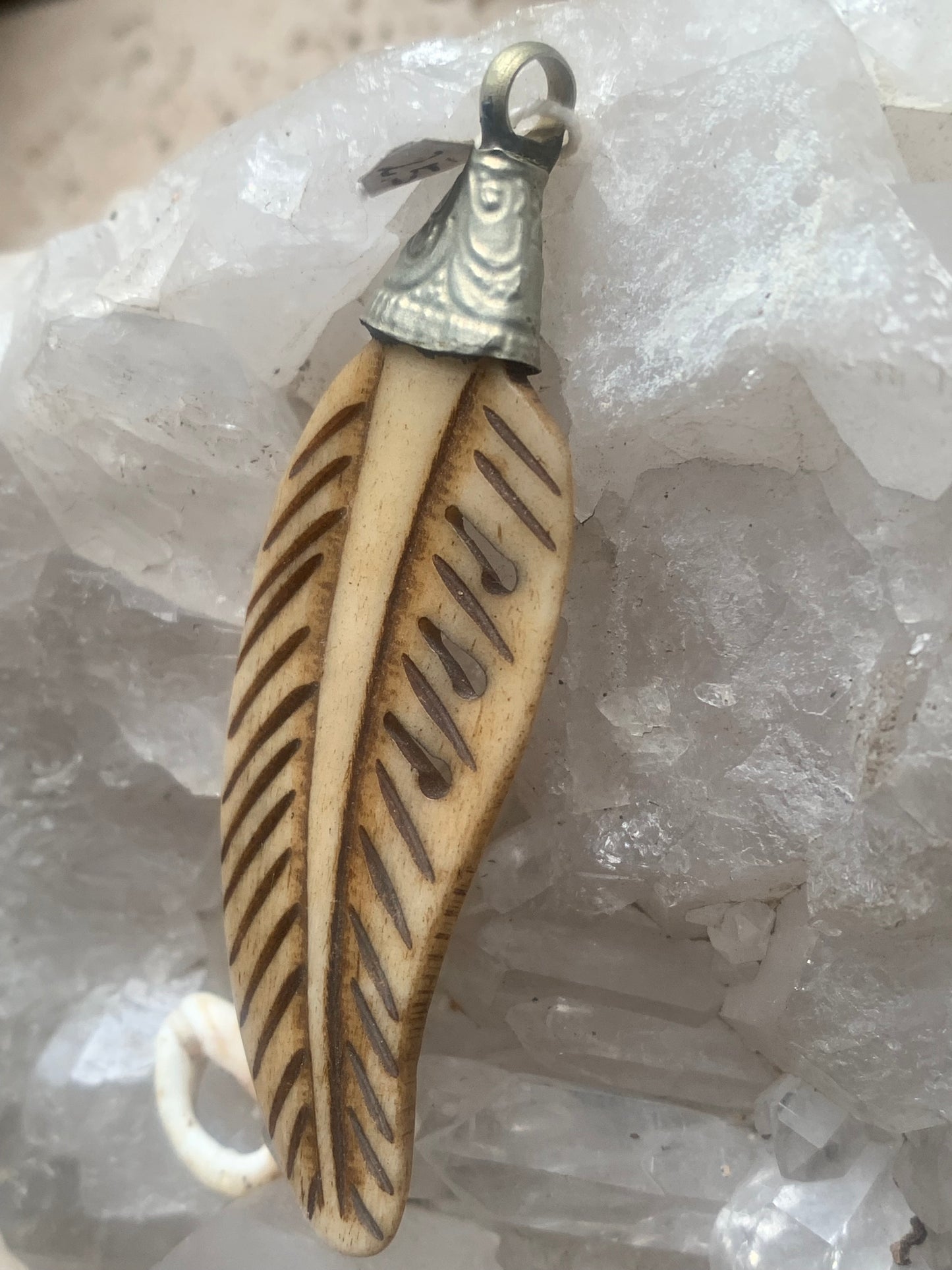 Pendentif artisanal du Népal en forme de plume, sculpté dans de l’os, de 70 millimètres de hauteur x 22 de largeur x 5 d'épaisseur. Vendu avec cordon noir réglable offert, parfait !