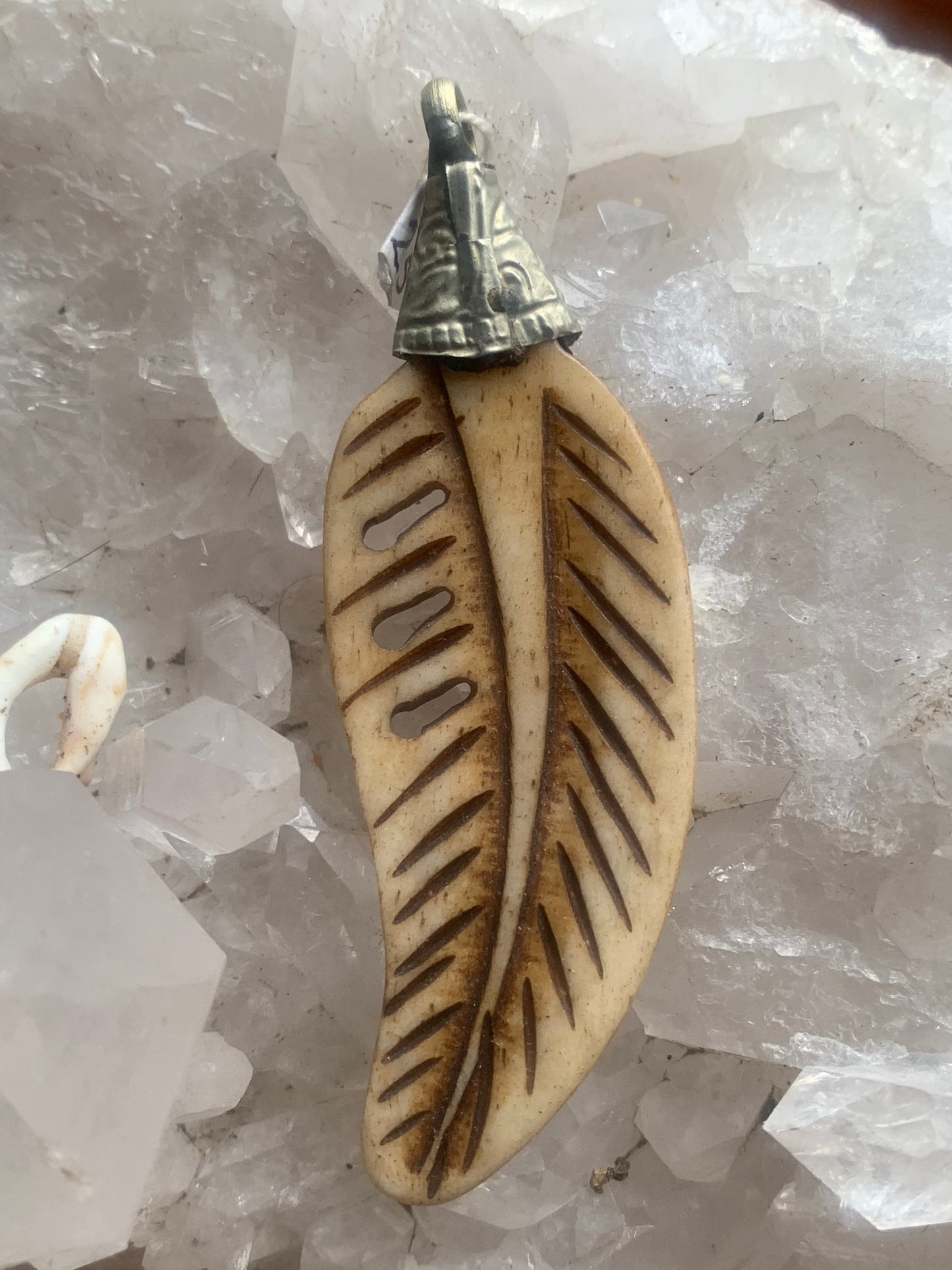 Pendentif artisanal du Népal en forme de plume, sculpté dans de l’os, de 70 millimètres de hauteur x 22 de largeur x 5 d'épaisseur. Vendu avec cordon noir réglable offert, parfait !
