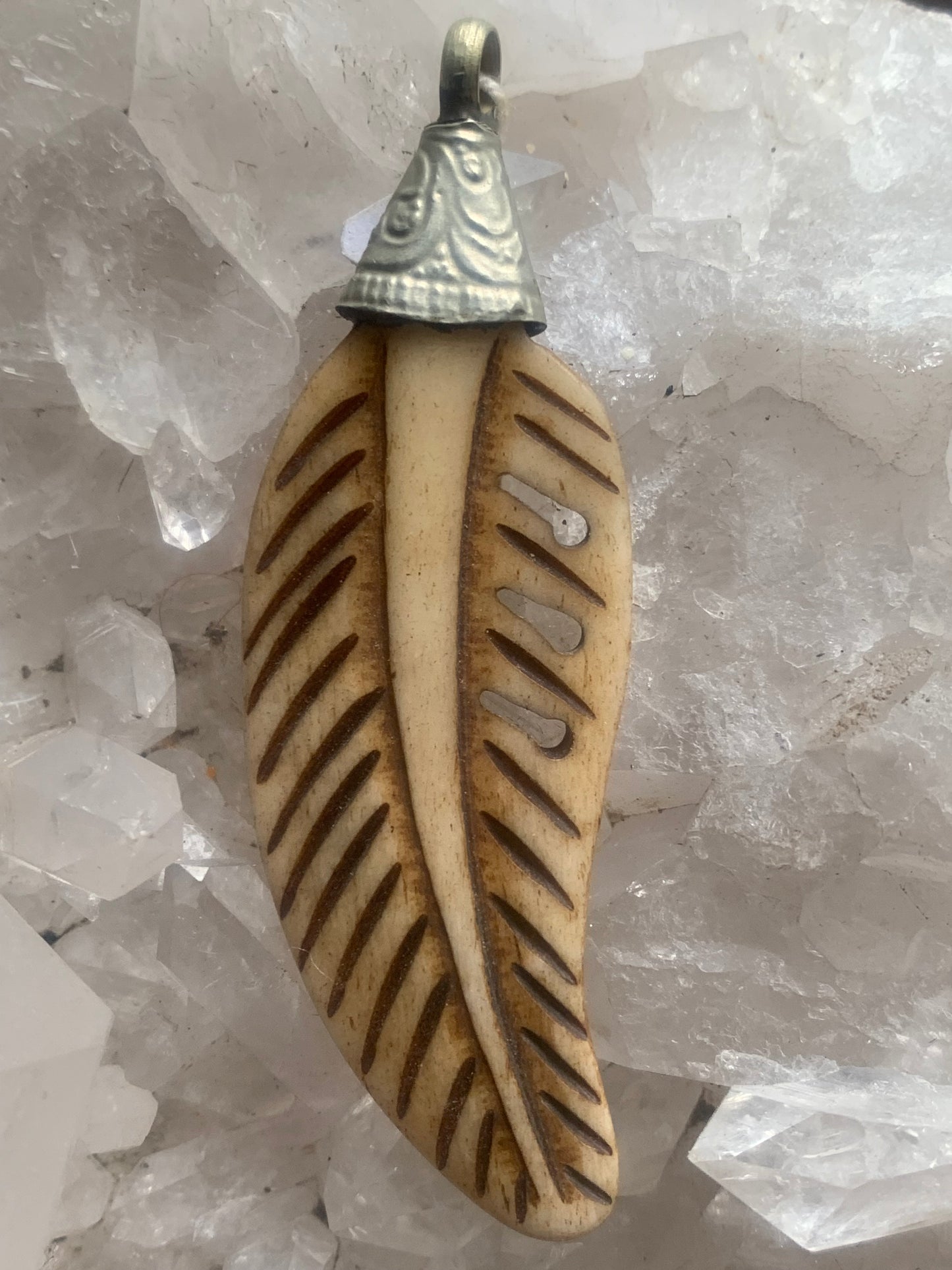 Pendentif artisanal du Népal en forme de plume, sculpté dans de l’os, de 70 millimètres de hauteur x 22 de largeur x 5 d'épaisseur. Vendu avec cordon noir réglable offert, parfait !