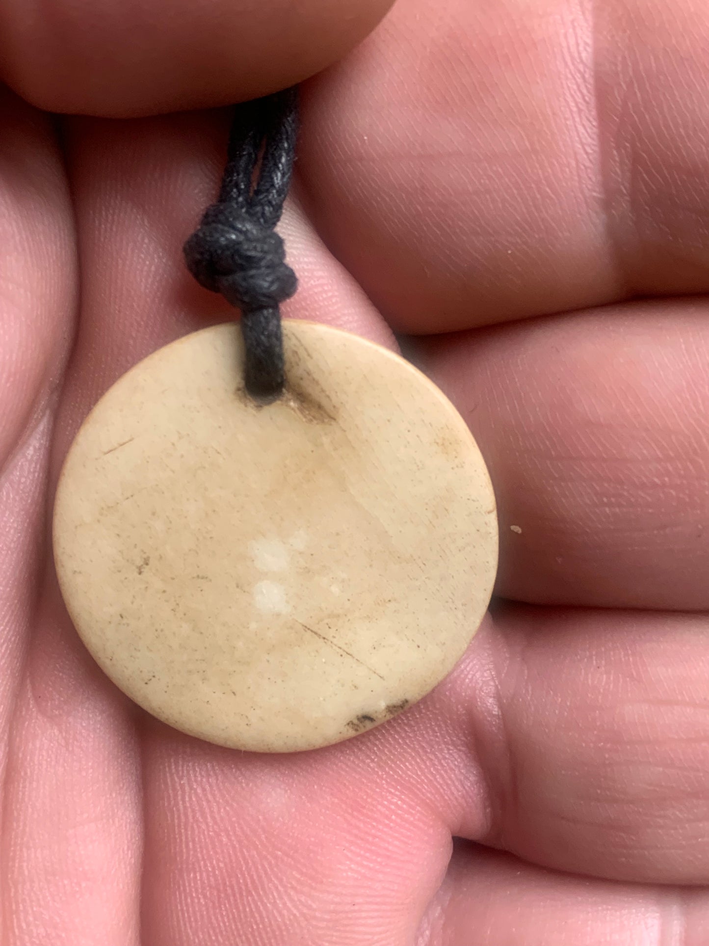 Pendentif artisanal du Népal avec symbole Om, sculpté dans de l’os, de 30 millimètres de diamètre x 4 mm d'épaisseur. Vendu avec cordon noir réglable offert, parfait !