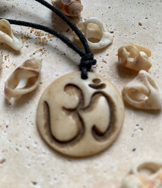 Pendentif artisanal du Népal avec symbole Om, sculpté dans de l’os, de 30 millimètres de diamètre x 4 mm d'épaisseur. Vendu avec cordon noir réglable offert, parfait !