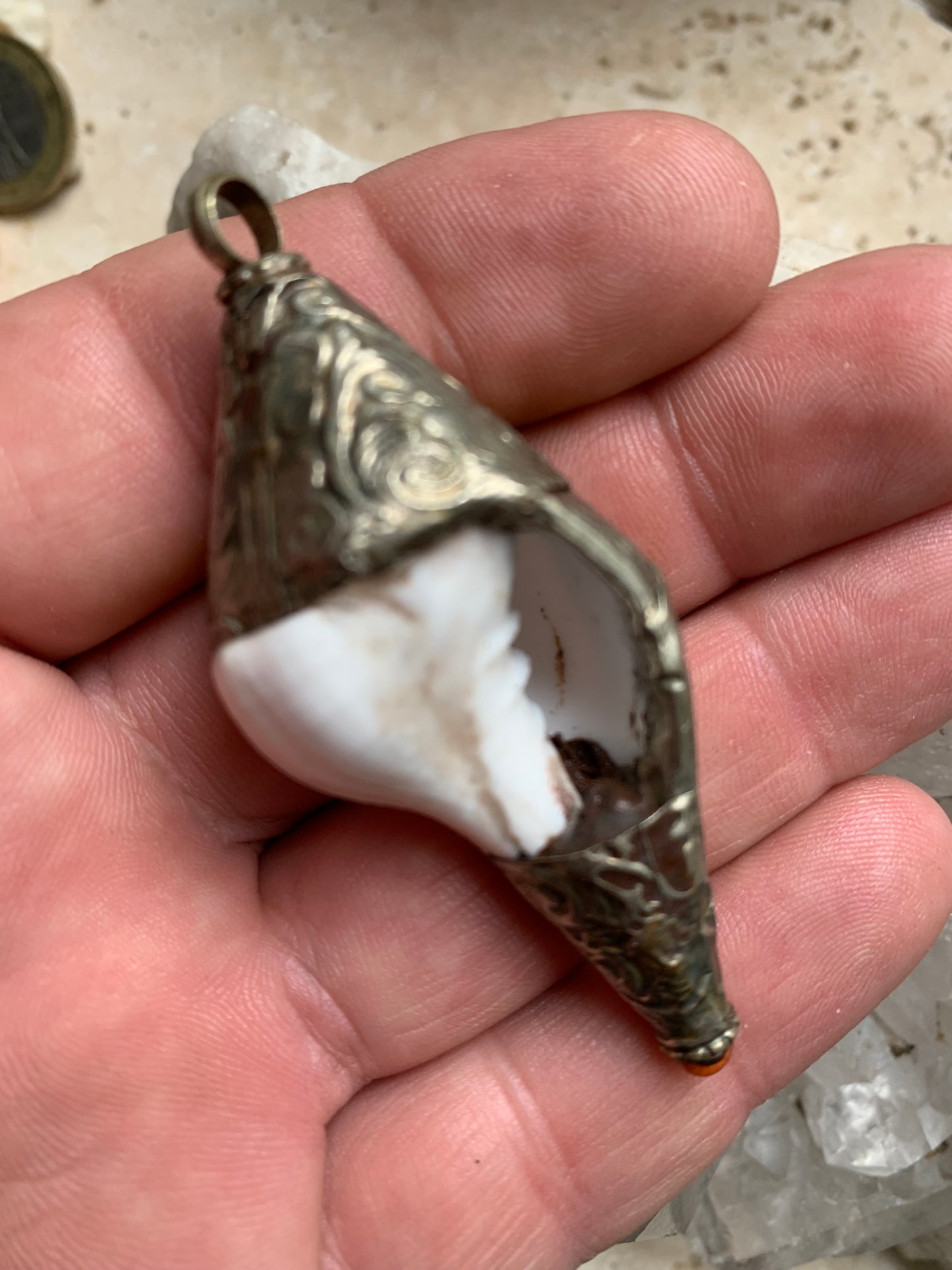 Pendentif artisanal du Népal en coquillage sertis en métal avec de jolies gravures et une perle de corail ! De 65 millimètres de hauteur x 28 mm de diamètre. Vendu avec cordon noir réglable offert, parfait !