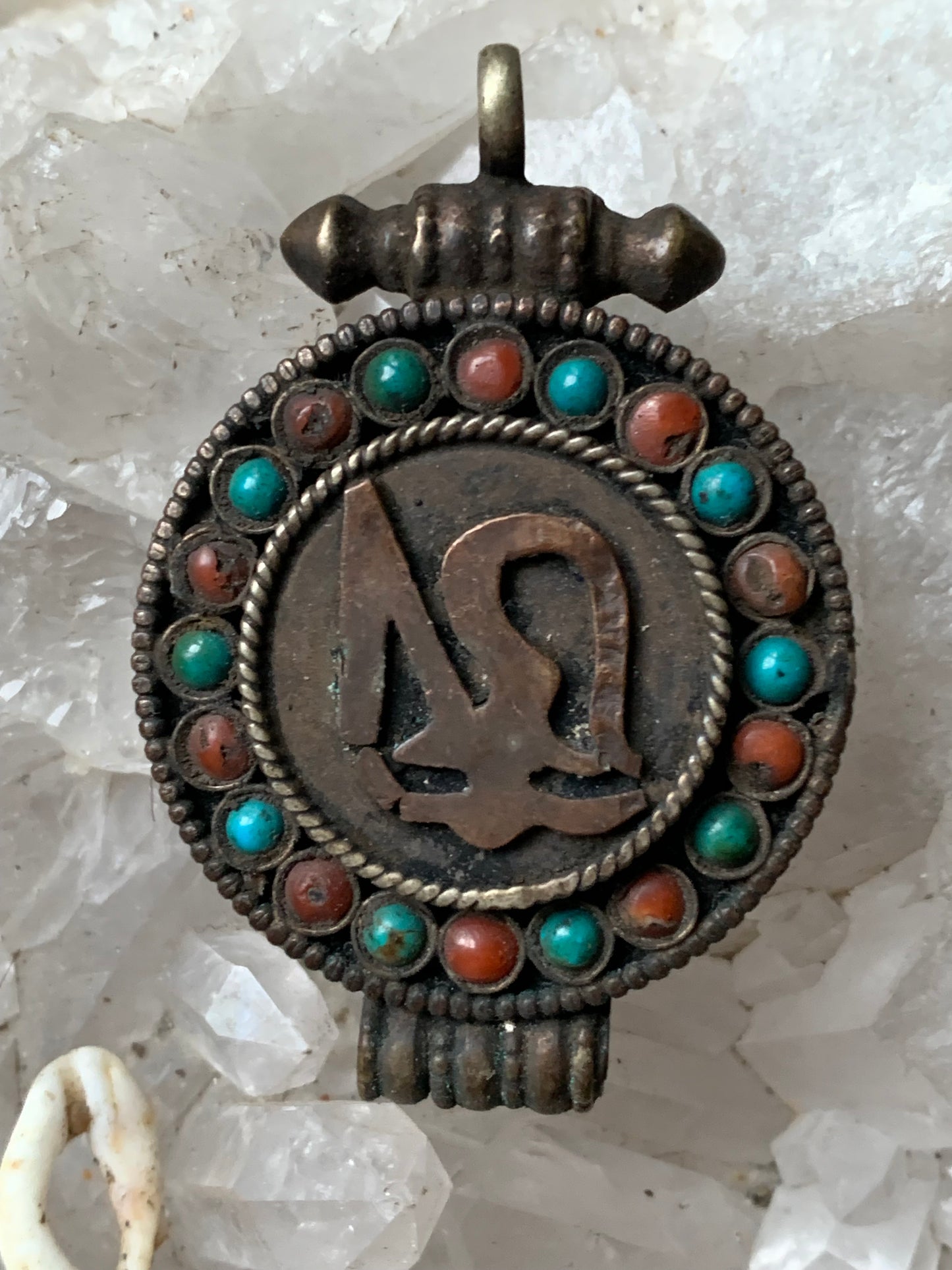 Pendentif/ Reliquaire artisanal du Népal avec pierres de turquoise et de corail sertis sur métal avec jolie gravure du Om ! De 52 millimètres de hauteur x 35 mm de largeur x 11 d'épaisseur. Vendu avec cordon noir réglable offert, parfait !