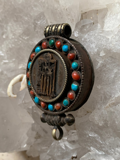 Handcrafted pendant/reliquary from Nepal with turquoise and coral stones set on metal with a beautiful Om engraving! 52 millimeters high x 35 mm wide x 11 mm thick. Sold with a free adjustable black cord, perfect!