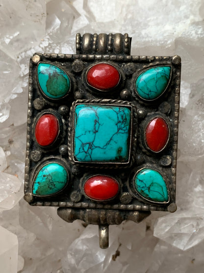 Pendentif/ Reliquaire artisanal du Népal avec pierres de turquoise et de corail sertis sur méta ! De 50 millimètres de hauteur x 35 mm de largeur x 17 d'épaisseur. Vendu avec cordon noir réglable offert, parfait !
