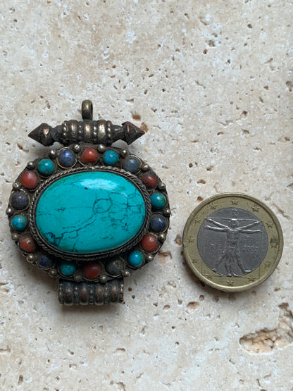Handcrafted pendant/reliquary from Nepal with turquoise and coral stones set in metal! 48 millimeters high x 37 mm wide x 18 mm thick. Sold with a free adjustable black cord, perfect!