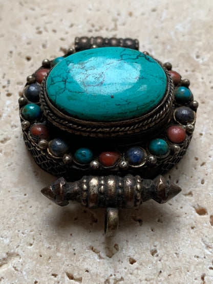Handcrafted pendant/reliquary from Nepal with turquoise and coral stones set in metal! 48 millimeters high x 37 mm wide x 18 mm thick. Sold with a free adjustable black cord, perfect!