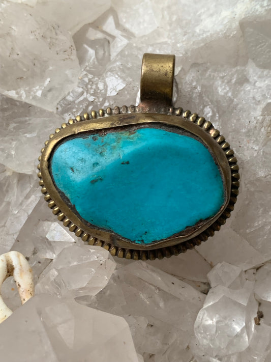 Pendentif artisanal du Népal avec pierres de turquoise sertis sur métal avec de jolies gravures sur la face arrière ! De 38 millimètres de hauteur x 37 mm de largeur x 14 d'épaisseur. Vendu avec cordon noir réglable offert, parfait !