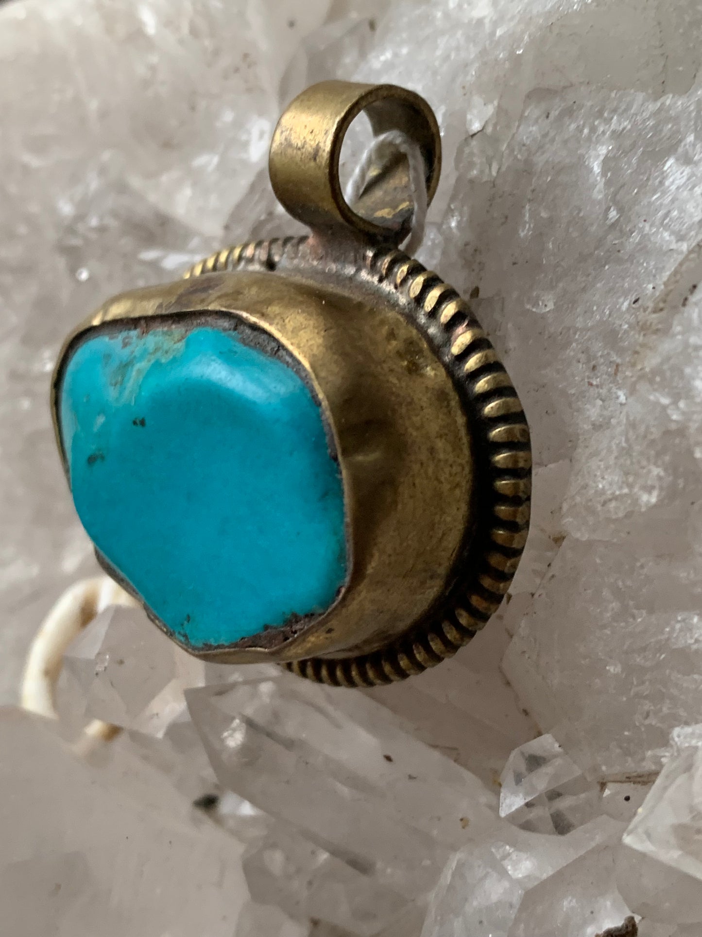 Pendentif artisanal du Népal avec pierres de turquoise sertis sur métal avec de jolies gravures sur la face arrière ! De 38 millimètres de hauteur x 37 mm de largeur x 14 d'épaisseur. Vendu avec cordon noir réglable offert, parfait !