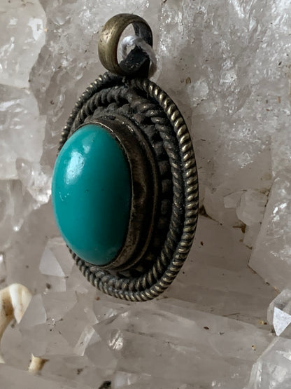 Pendentif artisanal du Népal avec pierres de turquoise sertis sur métal ! De 38 millimètres de hauteur x 26 mm de largeur x 11 d'épaisseur. Vendu avec cordon noir réglable offert, parfait !