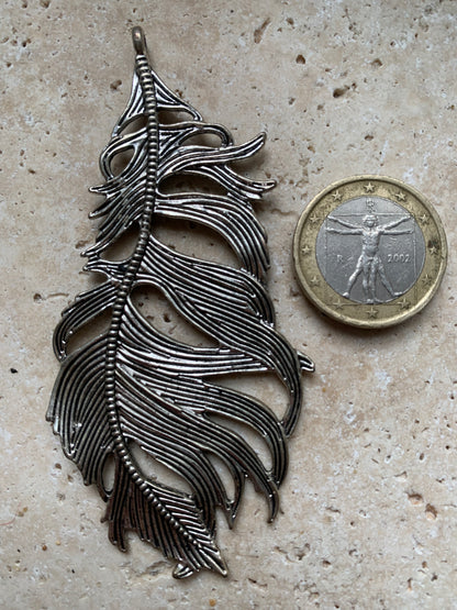 Pendentif en métal argenté en forme de plume. De 85 x 40 x 5 millimètres. Vendu avec cordon noir réglable offert, parfait !