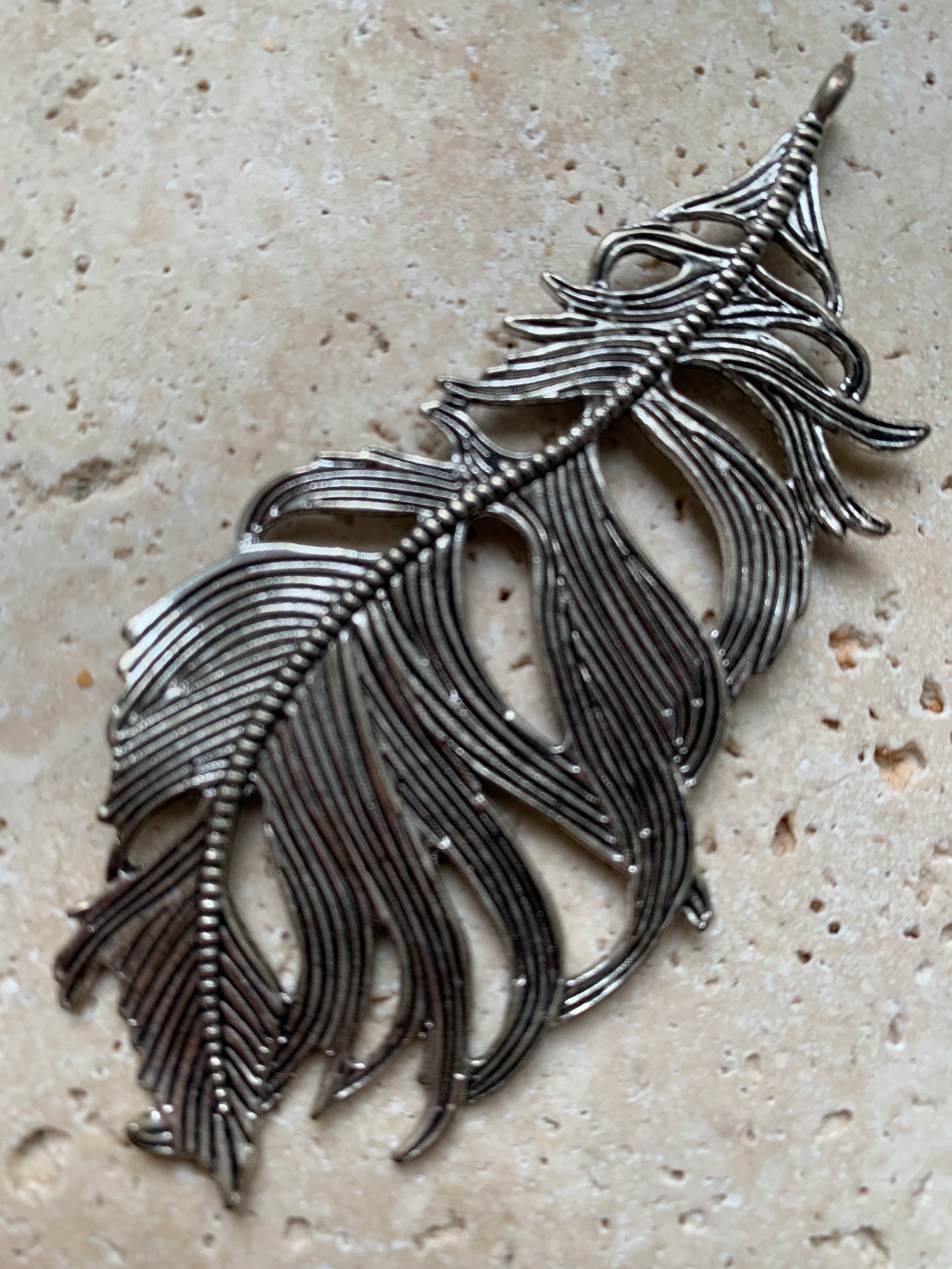 Pendentif en métal argenté en forme de plume. De 85 x 40 x 5 millimètres. Vendu avec cordon noir réglable offert, parfait !